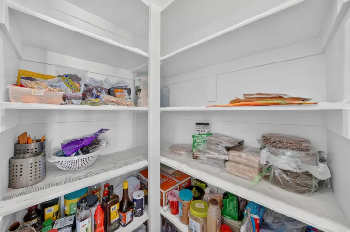 Built-in pantry with multiple white shelving units