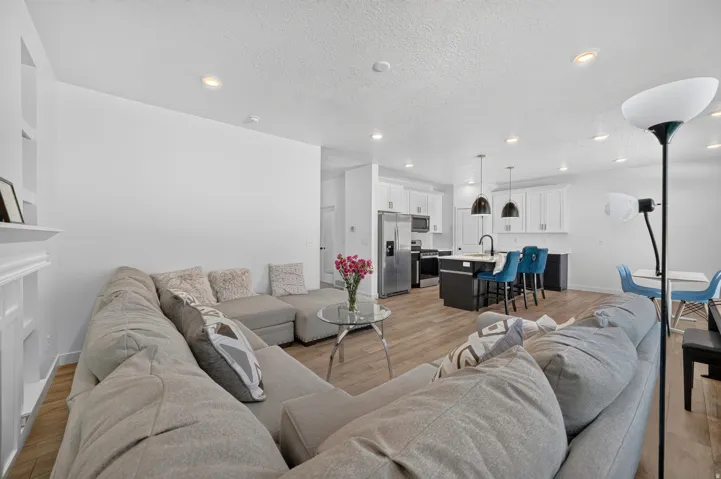 Open-concept living space featuring wood-finish flooring, recessed lighting, and a built-in shelving unit