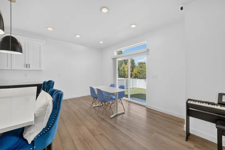 Open-concept living space with wood-finish flooring, recessed lighting, and a sliding glass door to the exterior