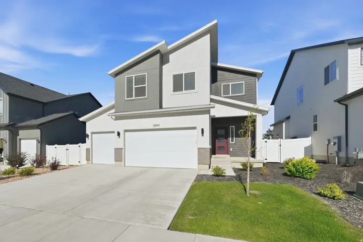 Contemporary two-story residence featuring a striking architectural design with contrasting gray and white stucco siding