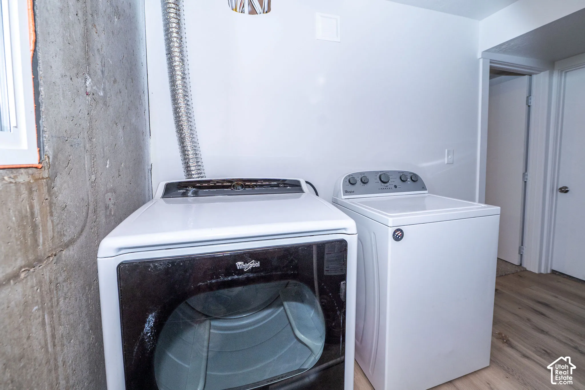 Dedicated laundry area featuring a white top-load washing machine and a front-load dryer