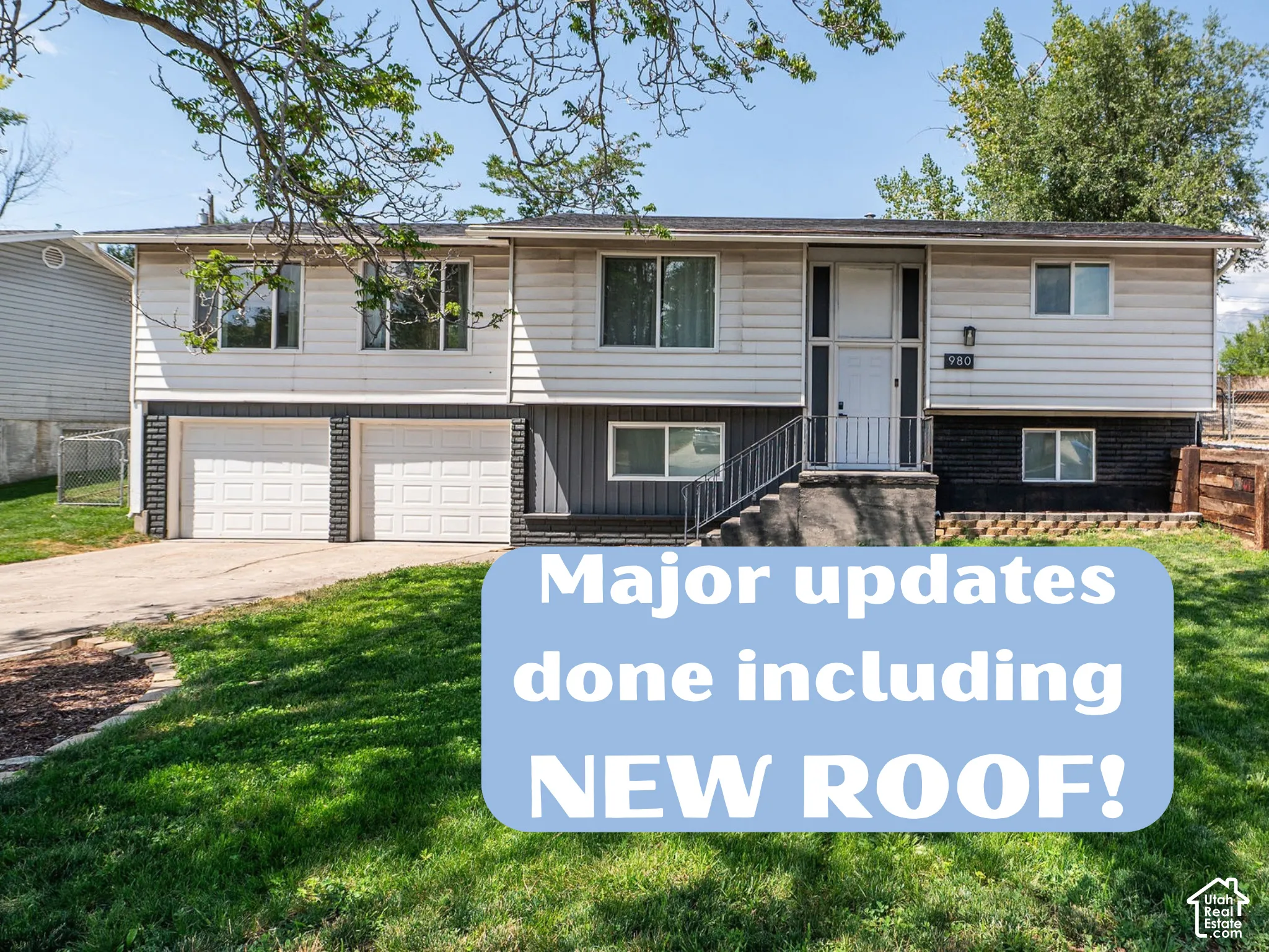 Bi-level exterior featuring horizontal and vertical siding, a two-car garage, and asphalt shingle roofing
