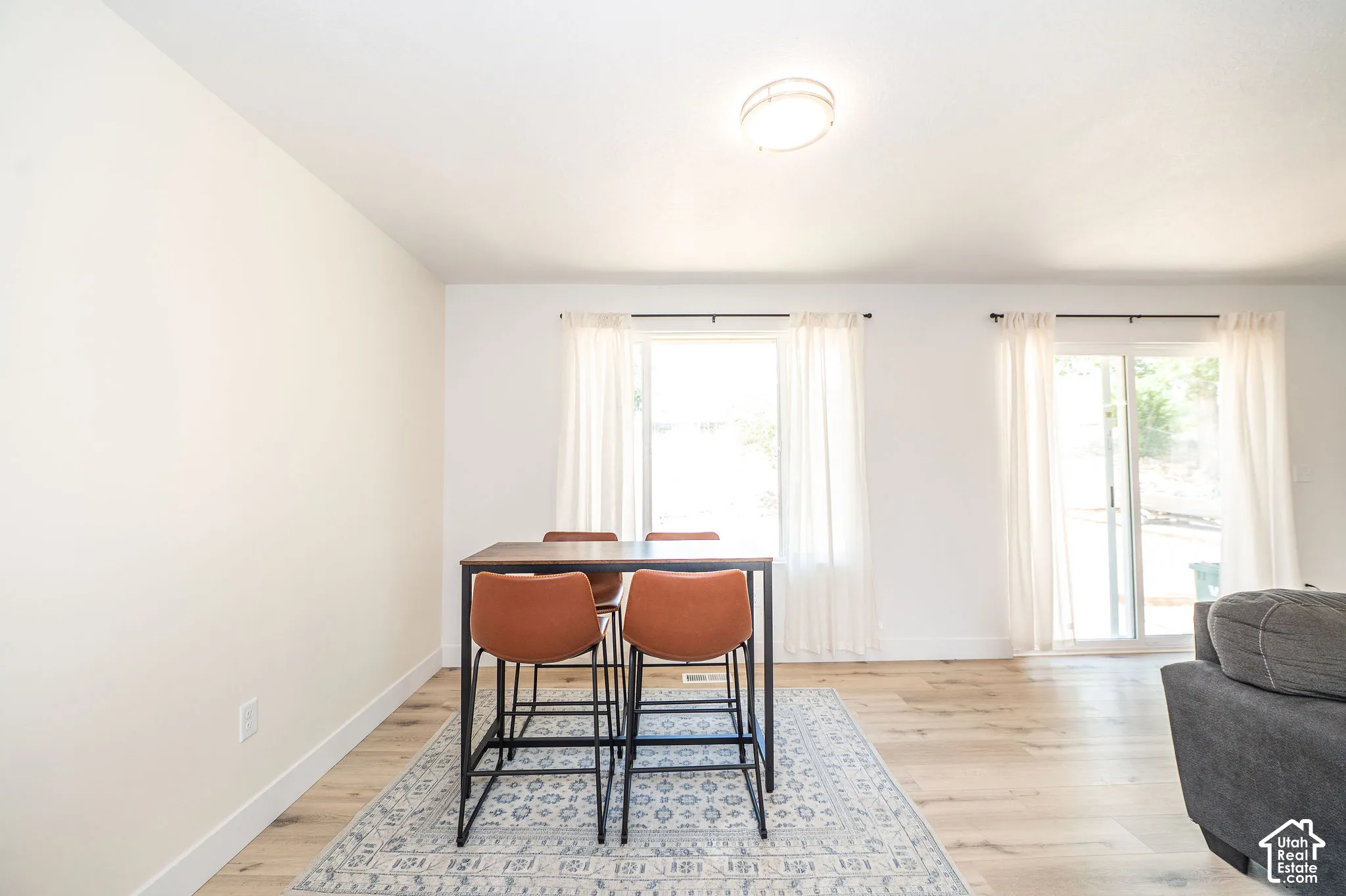 Open-concept room featuring light wood-finish flooring, white walls, and a flush-mount ceiling light fixture