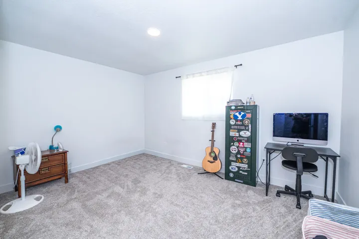 Neutral-toned carpeted flooring complements white walls and recessed lighting