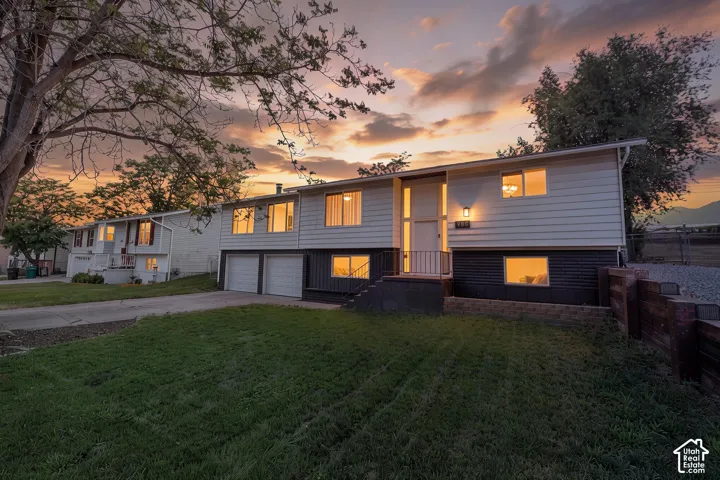 Split-level residence featuring light-colored siding and a dark-toned lower level