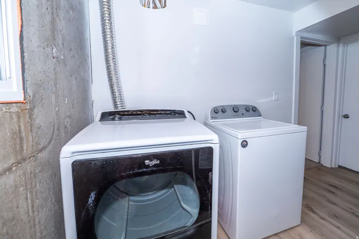 Dedicated laundry area featuring a white top-load washing machine and a front-load dryer