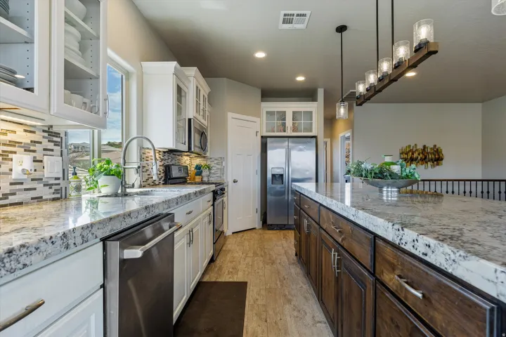 Spacious kitchen featuring white upper cabinetry, dark wood-finish lower cabinetry, and light-toned countertops