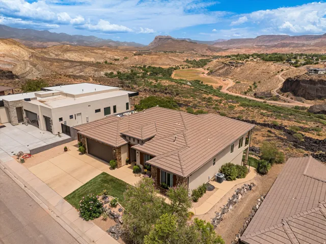 Contemporary residence featuring a brown tile roof, a two-car garage, and a manicured lawn