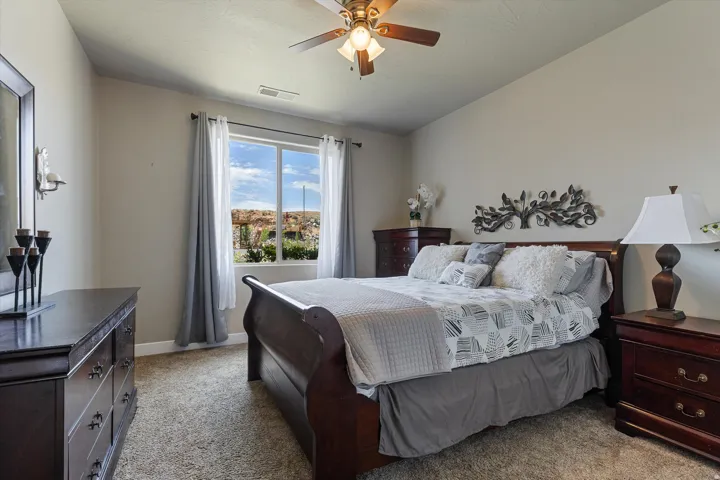 Spacious room featuring vaulted ceilings, a ceiling fan, and carpeted flooring