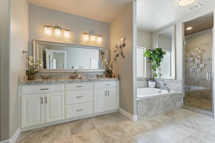 Bathroom featuring a double vanity with granite-style countertops, dual rectangular undermount sinks, and polished chrome fixtures