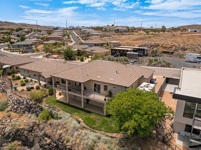 Multi-level residence featuring a neutral stucco exterior and a tiled roof