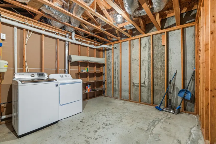 Unfinished basement featuring exposed wood framing, concrete walls, and concrete flooring