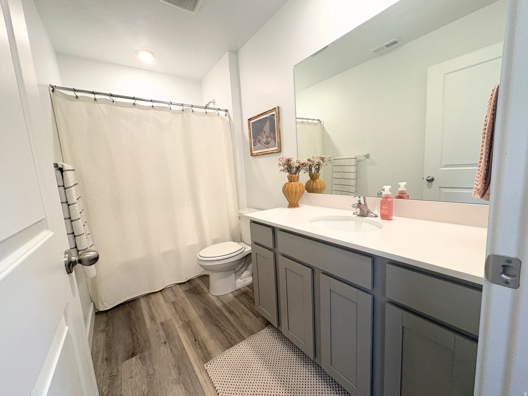 Modern bathroom featuring a single vanity with a white countertop, undermount sink, and brushed nickel faucet