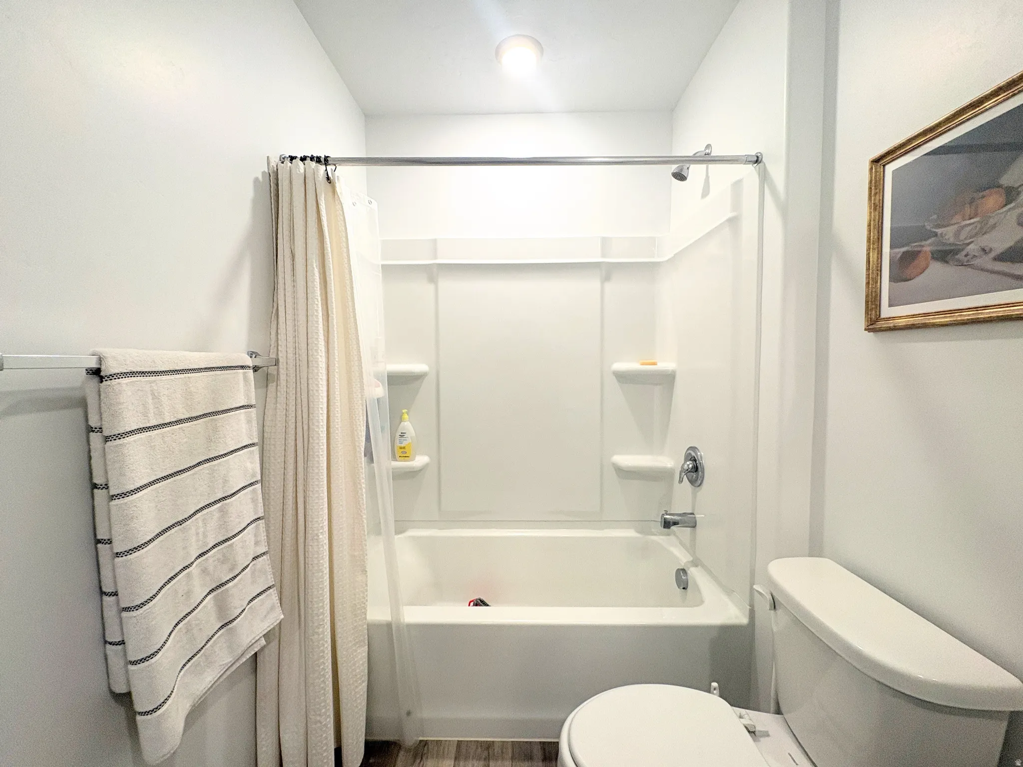 White acrylic tub and shower combination with chrome fixtures