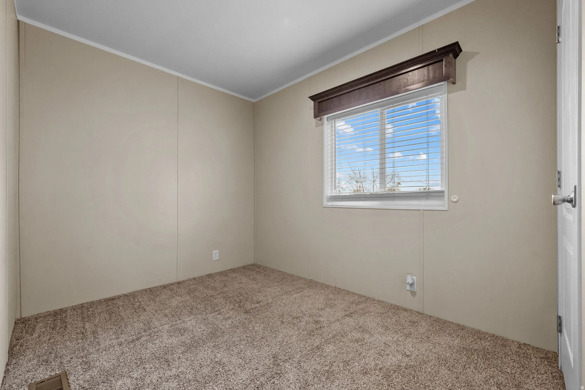 Neutral-toned walls complement the textured carpet flooring