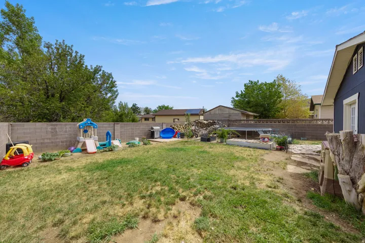 Expansive backyard featuring a block wall perimeter and mature trees