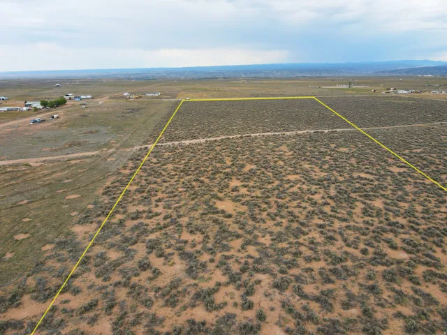 Expansive undeveloped land parcel featuring natural shrubbery and a distant horizon