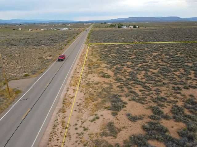 Expansive vacant land parcel featuring direct road frontage and distant mountain ranges