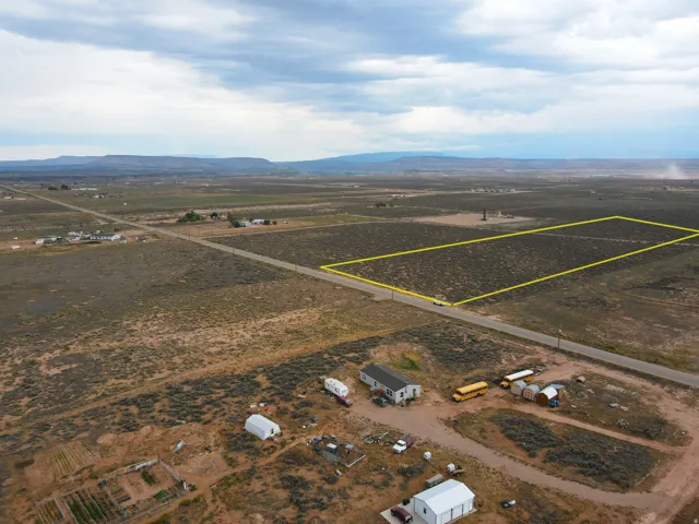 Expansive undeveloped land featuring a rectangular shape, natural desert vegetation, and direct road frontage