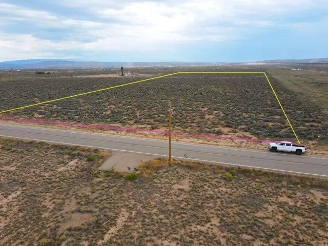 Expansive undeveloped land bordering a paved road, featuring natural desert vegetation