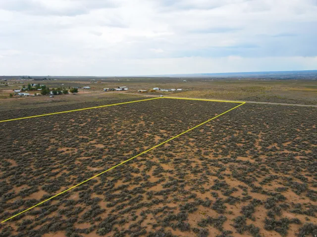 Expansive desert landscape featuring a clear, open land parcel outlined in yellow