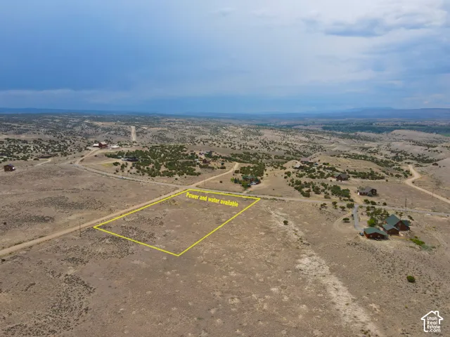 Expansive undeveloped land featuring a defined lot boundary, existing utility access, and surrounding residences