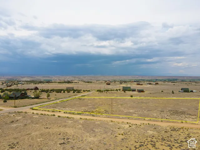 Expansive parcel of land bordered by a dirt road, featuring a distant mountainous backdrop