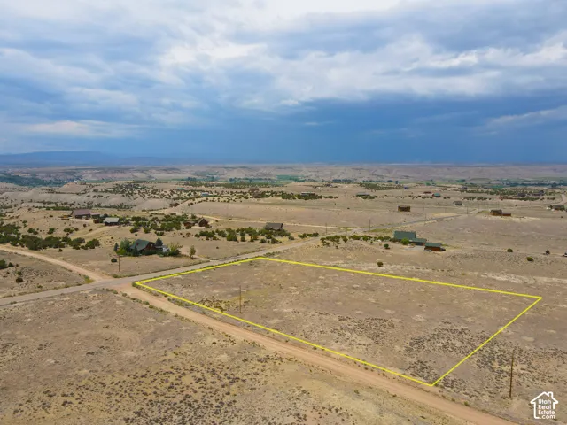 Expansive desert landscape featuring a marked rectangular lot, surrounded by natural terrain