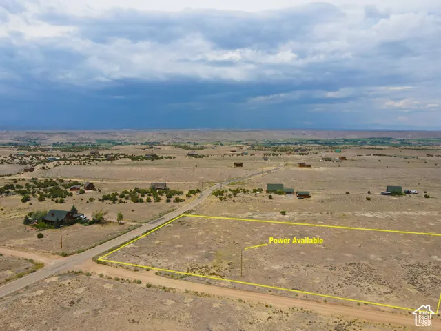 Expansive land parcel featuring arid vegetation and distant structures