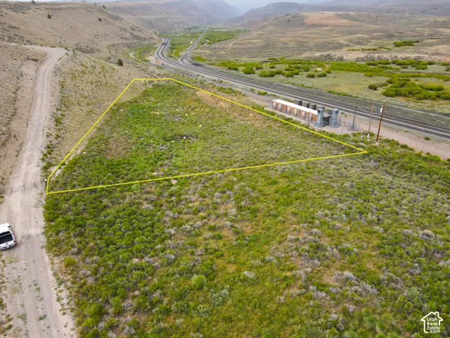 Expansive undeveloped land featuring natural vegetation and a dirt road entrance