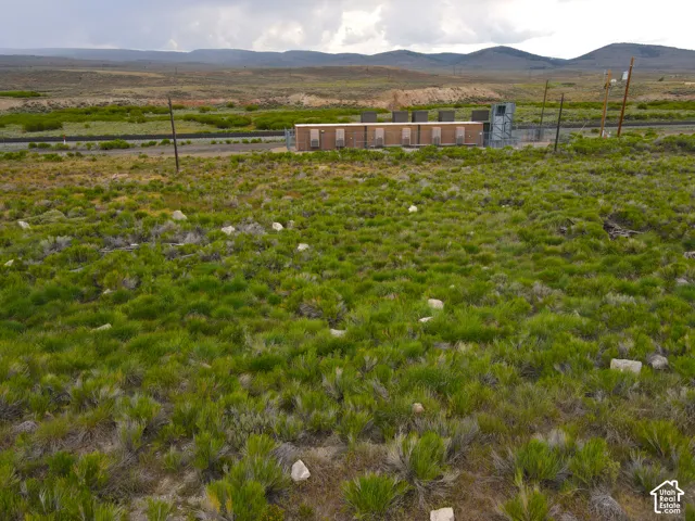 Expansive undeveloped land featuring varied green foliage and scattered rocks