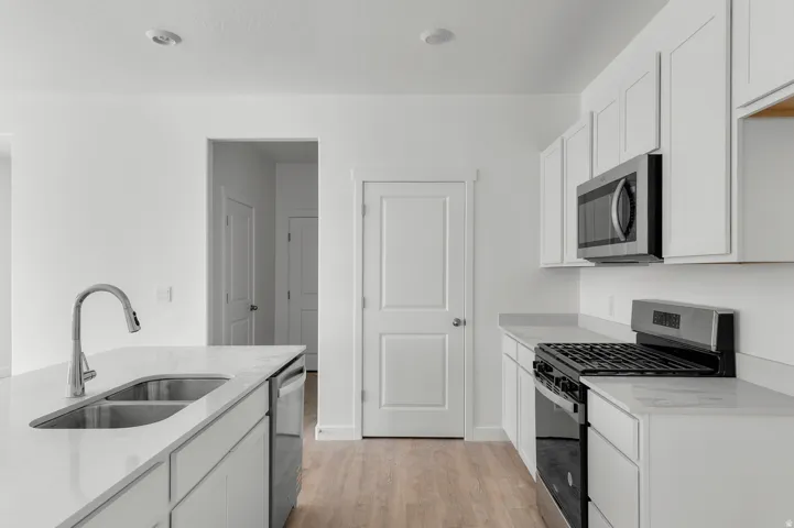 Bright kitchen featuring white cabinetry and light countertops