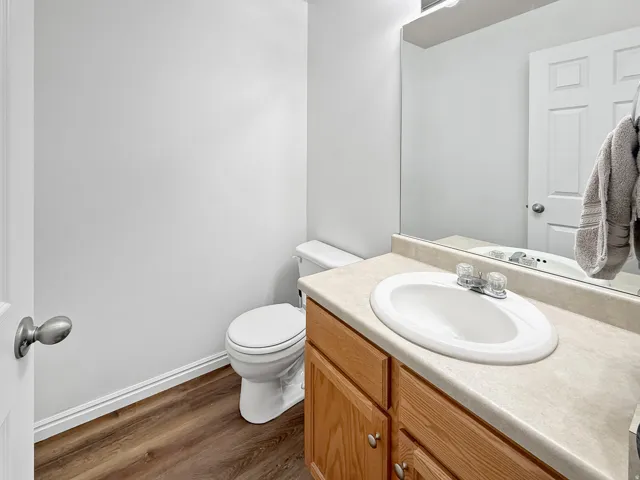 Bathroom featuring a vanity with a laminate countertop, an oval sink, and a mirror.