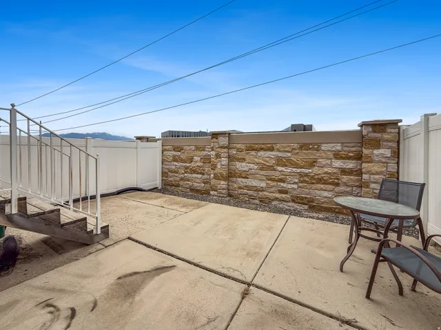 Private patio space featuring concrete paving and a decorative stone privacy wall