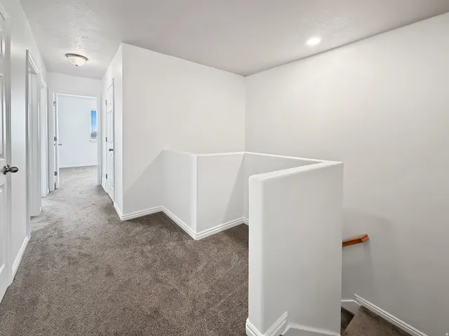 Carpeted hallway featuring white walls, white trim, recessed lighting, and a semi-flush mount ceiling fixture