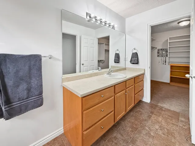 Spacious bathroom vanity with a single basin sink, ample counter space, and light wood-finish cabinetry