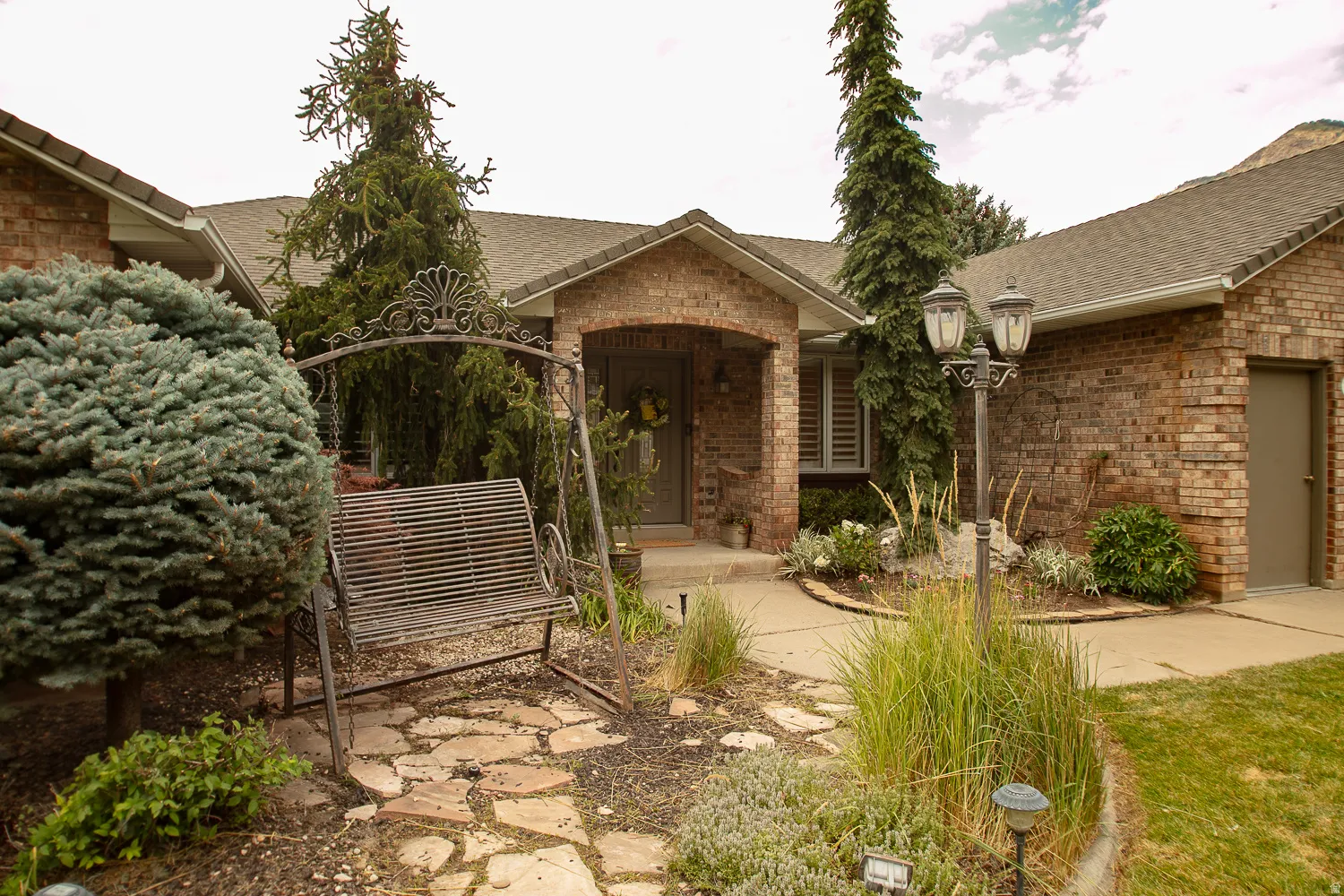 Brick exterior featuring a covered entry and an attached garage