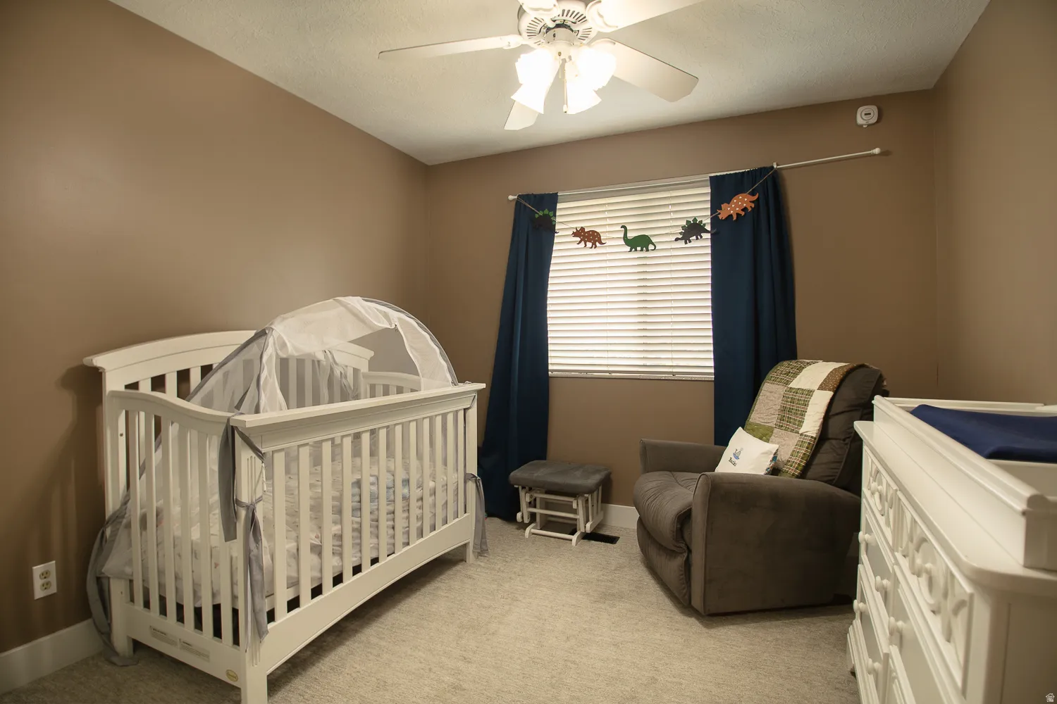 Carpeted room with a ceiling fan, window blinds, and neutral wall tones