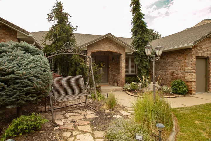 Brick exterior featuring a covered entry and an attached garage
