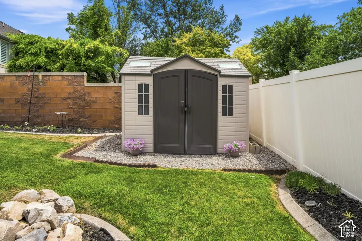 Backyard storage shed featuring dual entry doors, two window accents, and skylights