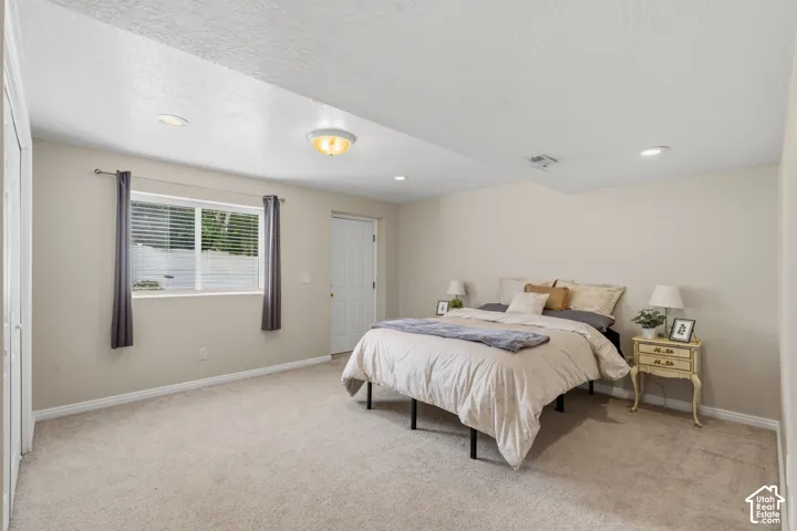 Carpeted room with neutral wall tones and white baseboards and exterior entrance