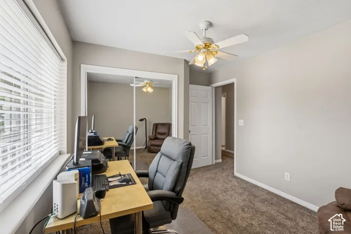 Room featuring textured carpeting, a window with horizontal blinds, and neutral painted walls