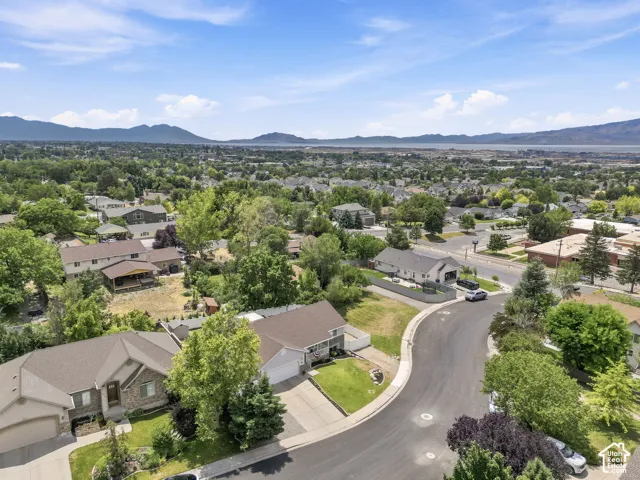 Aerial perspective showcasing a residential neighborhood with distant mountains and a body of water