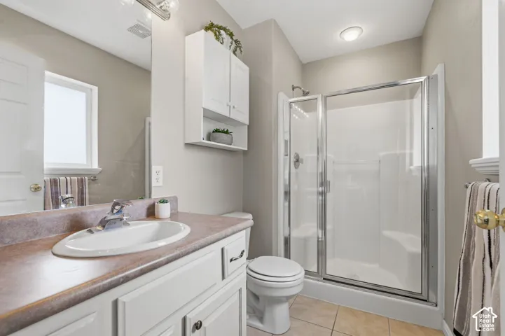 Primary Bathroom featuring a white vanity with a laminate countertop, an oval undermount sink, and a chrome faucet
