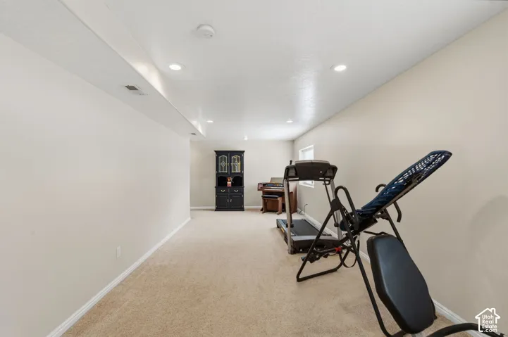 Carpeted room with recessed lighting, light-toned walls, and a single window