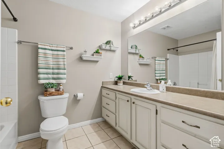 Hall Bathroom featuring a spacious vanity with an integrated sink, cream-colored cabinetry, and a full-width mirror