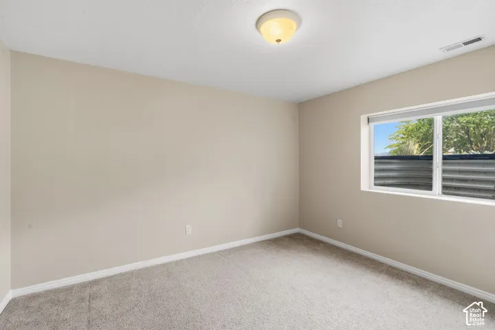 Carpeted room with neutral-toned walls, white baseboards, and a semi-flush ceiling light fixture