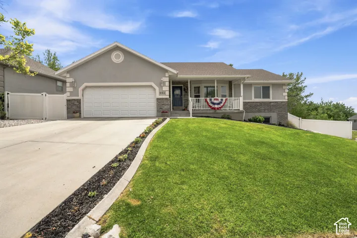 Ranch-style residence featuring a prominent two-car garage, covered front porch, and a concrete driveway
