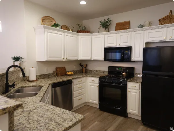 Kitchen featuring white cabinetry, granite countertops, stainless steel double-basin sink with a matte black faucet, and wood-finish flooring