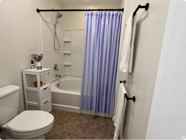 Bathroom featuring a white tub and shower combination with a curved basin